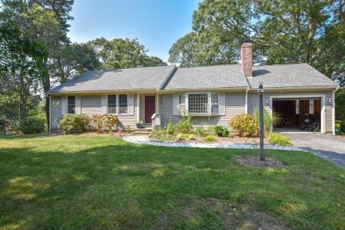 a house with a yard with a driveway at Pond Front Home with Private Dock in Brewster