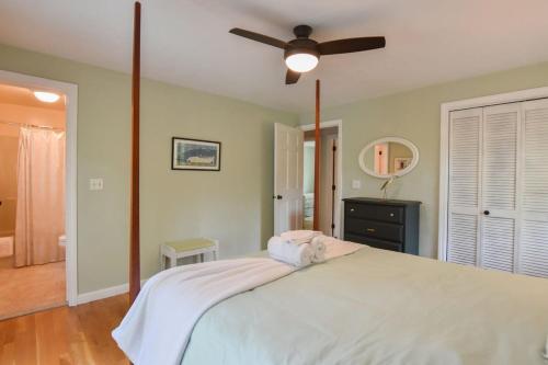 a bedroom with a large bed with a ceiling fan at Pond Front Home with Private Dock in Brewster