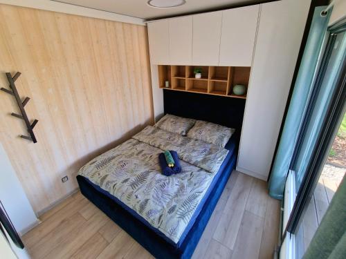 a small bedroom with a bed in a room at Lisi Ogon zanurzeni w naturze in Lisi Ogon