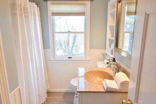 baño con lavabo y aseo y ventana en Beautiful Home Close to Ponds and Beach, en Brewster