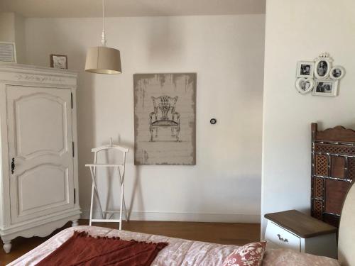 a room with a bed and a picture on the wall at LA VILLA BOLERO in Saint-Cyr-sur-Loire
