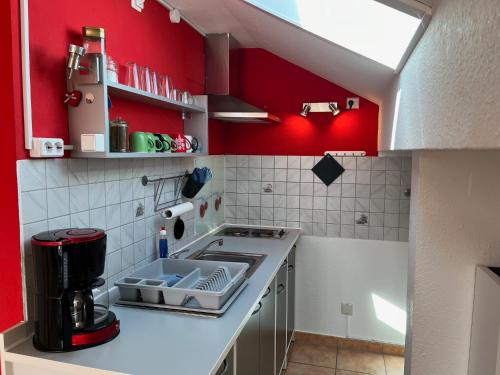 a small kitchen with red walls and a stove at Allgäutraum Ferienwohnung Nr. 2 in Kempten