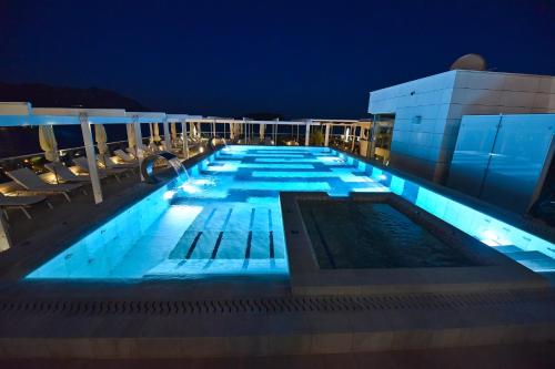 een zwembad op de top van een gebouw 's nachts bij Lux Apartments Sunrior in Budva