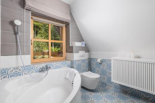 a bathroom with a tub and a toilet and a window at Forest Tale - Šumska priča in Crni Lug