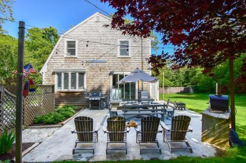 a patio with chairs and a table with an umbrella at Stunning Home with Wet Bar Dog Welcome! in Brewster