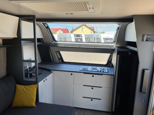 an interior of an rv with a kitchen and a window at przyczepa in Jastarnia