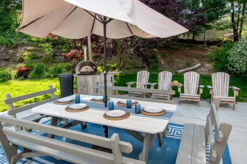 a table with hats and an umbrella on a patio at Stunning Home with Wet Bar Dog Welcome! in Brewster