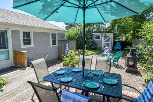 a blue table with chairs and an umbrella at Mins to Beach & Town Great Outdoor Space in Dennis