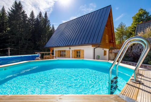 a pool in front of a house with a barn at Forest Tale - Šumska priča in Crni Lug
