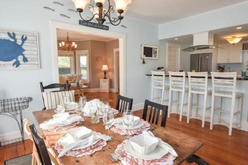 a dining room and kitchen with a table and chairs at Walk to Beach at Historic Sears Kit Home in Dennis