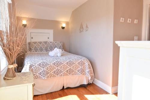 a bedroom with a bed with a cat on it at Walk to Beach at Historic Sears Kit Home in Dennis