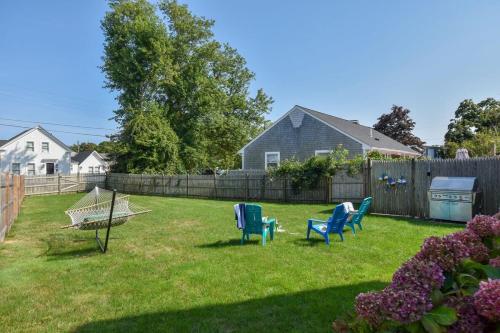 a yard with two chairs and a fence at Walk to Beach at Historic Sears Kit Home in Dennis