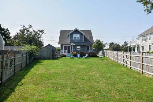 a yard with a fence and a house at Walk to Beach at Historic Sears Kit Home in Dennis