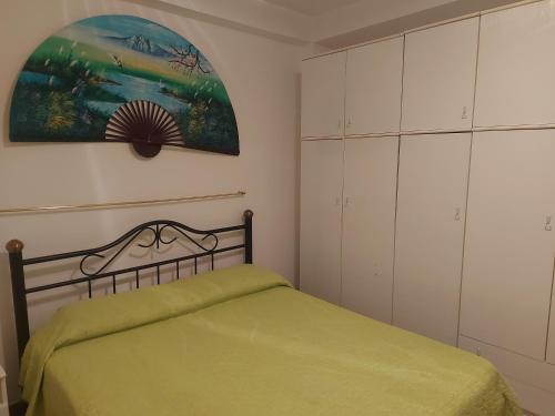 馬里納－迪拉古薩的住宿－A casa di Franco，一间卧室配有一张绿色的床和白色的橱柜。