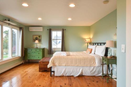 a bedroom with a bed and a green wall at Waterfront Fun Dogs Welcome in Dennis