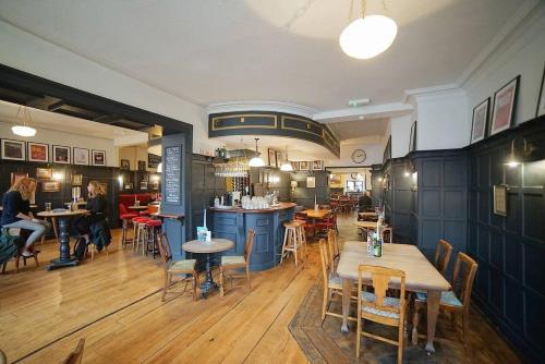 ein Restaurant mit Tischen und Stühlen und eine Bar in der Unterkunft The Alma Taverns Boutique Suites - Room 4 - Hopewell in Bristol
