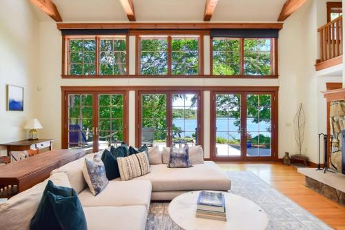 a living room with a lot of windows at Pristine waterfront oasis plus game room jacuzzi and home office in Orleans