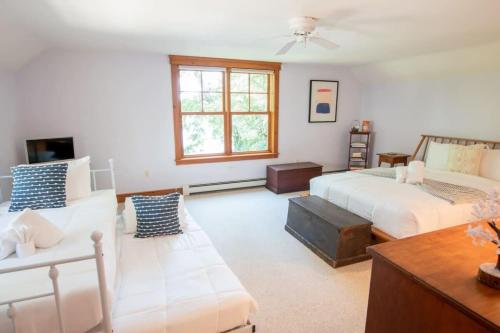 a living room with two beds and a couch at Pristine waterfront oasis plus game room jacuzzi and home office in Orleans