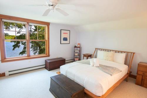 a bedroom with a large bed and a window at Pristine waterfront oasis plus game room jacuzzi and home office in Orleans