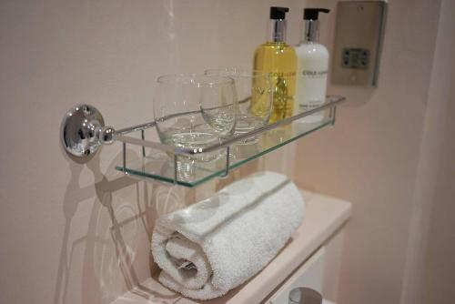 a glass shelf in a bathroom with two glasses and wine bottles at The Alma Taverns Boutique Suites Room 2 - Hopewell in Bristol