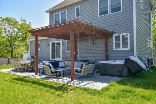 a pergola on a patio in front of a house at Stunningly Decorated Home with Hot Tub in Yarmouth