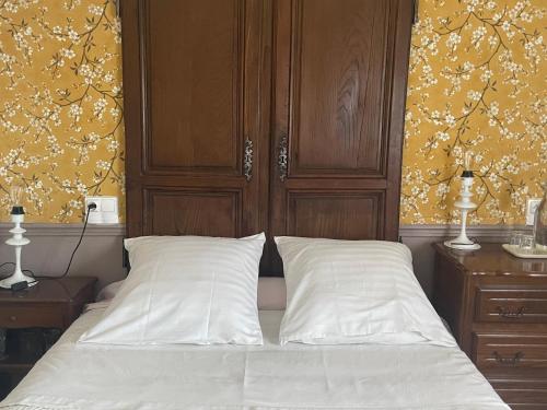 a bed with two white pillows and a wooden headboard at La Bonne Maison 3 - Maison d'hôtes in Troyes