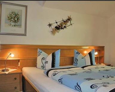 a bedroom with a bed with a wooden head board at Gästehaus Resi in Jerzens