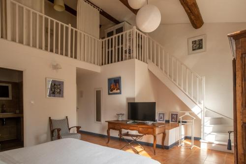 a bedroom with a bed and a desk with a television at HOTEL et APPARTEMENTS DOMAINE DES CLOS - Teritoria in Beaucaire