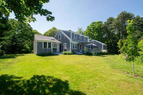 a house with a large yard with a house at Sleeps 8 Minutes to Nauset Beach in Orleans