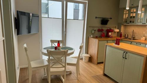 a kitchen with a table and chairs in a kitchen at Apartament Pastelove Żywiec in Żywiec