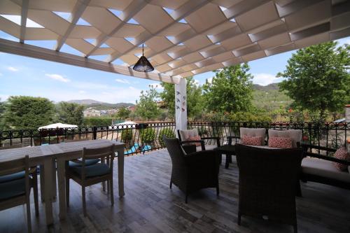 a patio with a table and chairs on a deck at Villa TN - Fethiye in Fethiye