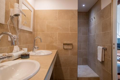 a bathroom with a sink and a shower at HOTEL et APPARTEMENTS DOMAINE DES CLOS - Teritoria in Beaucaire