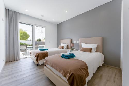 サン・ブラース・デ・アルポルテルにあるVilla Almargensのベッドルーム1室(ベッド2台付)、バルコニーが備わります。
