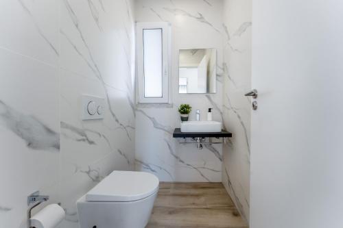 Un baño blanco con inodoro y lavabo. en Villa Almargens, en São Brás de Alportel