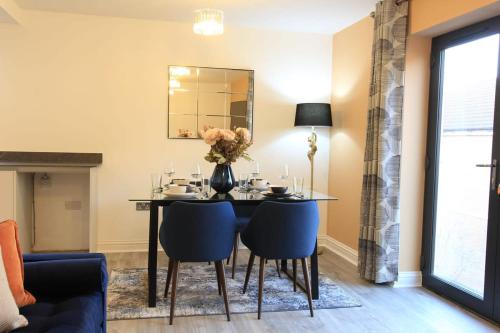 a dining room with a table and blue chairs at Cabot Mews Apartment 7 in Bristol
