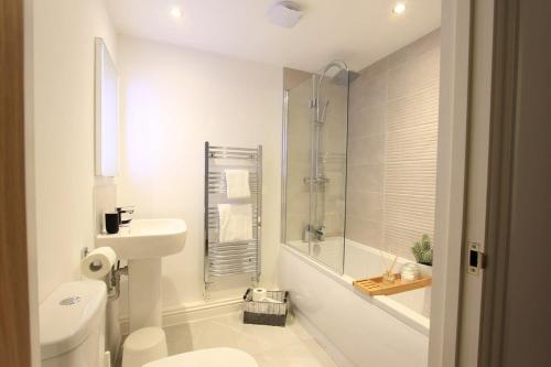 a white bathroom with a toilet and a shower at Cabot Mews Apartment 7 in Bristol