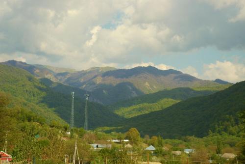 a view of a mountain range with trees and houses at Istisu Valley Spa in İsmayıllı