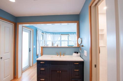 a bathroom with a sink and a mirror at Beautiful backyard pool deeded beach rights in Truro