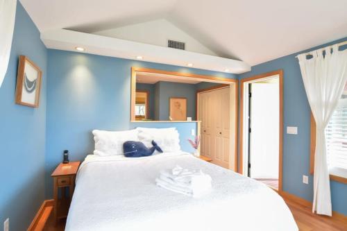 a blue bedroom with a large white bed at Beautiful backyard pool deeded beach rights in Truro