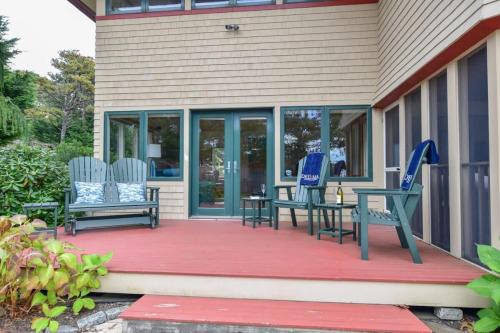 a porch with two chairs and a table on it at Beautiful backyard pool deeded beach rights in Truro