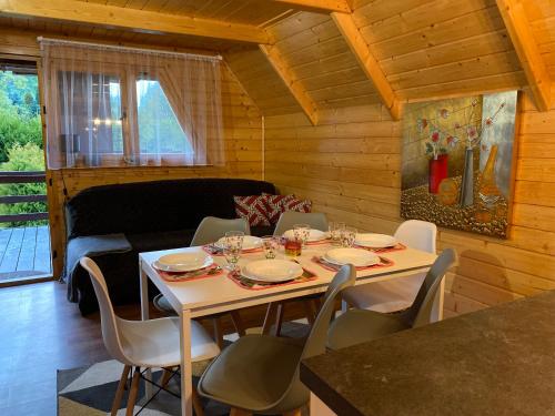 a dining room with a table and chairs and a couch at Cudowny Świat in Rożnów