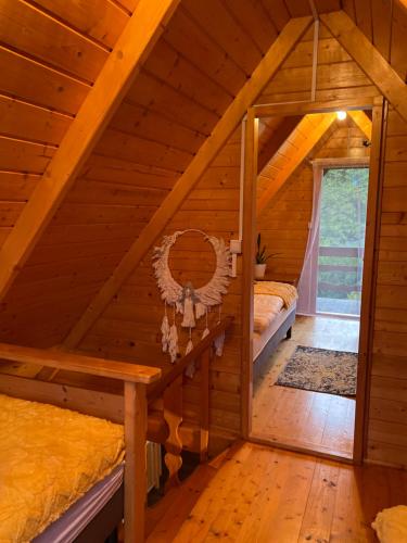 a room with two beds in a wooden cabin at Cudowny Świat in Rożnów