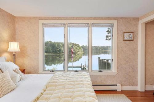 een slaapkamer met een groot bed en een groot raam bij Waterfront Incredible Views and Private Dock in Yarmouth