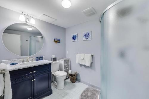 een badkamer met een wastafel, een toilet en een spiegel bij Waterfront Incredible Views and Private Dock in Yarmouth