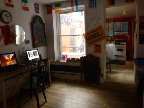 a kitchen with a window and a table with a sign at Auberge Jeunesse La Belle Planete Backpackers Hostel in Quebec City