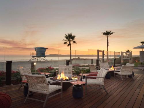 eine Terrasse mit Stühlen und einem Tisch mit Kamin in der Unterkunft Hotel del Coronado, Curio Collection by Hilton in San Diego