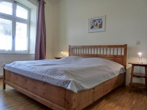 um quarto com uma cama de madeira e uma janela em Ferienwohnung LVC11 em Graal-Müritz