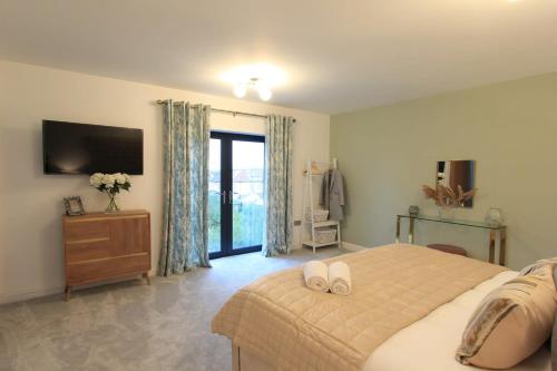 um quarto com uma cama grande e uma televisão em Cabot Mews Apartment 8 em Bristol