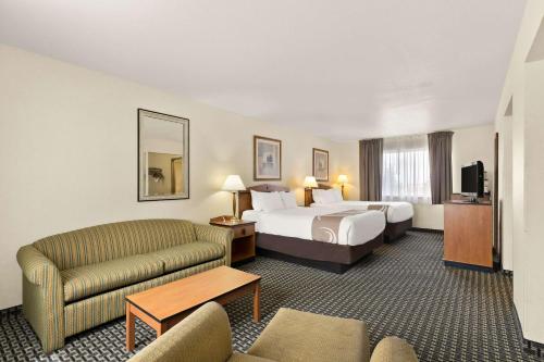 a hotel room with a bed and a couch at Quality Inn Cheyenne I-25 South in Cheyenne