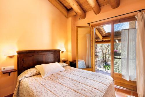 a bedroom with a bed and a large window at Mas Cal Gintó in Das